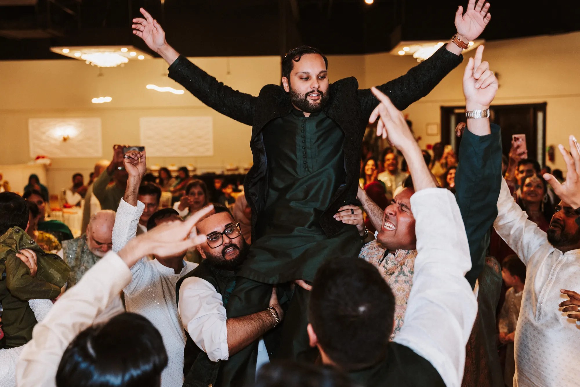 Bride and groom on a floral swing mandap stage during their Desi wedding celebration, photographed by Weddings Unlimited