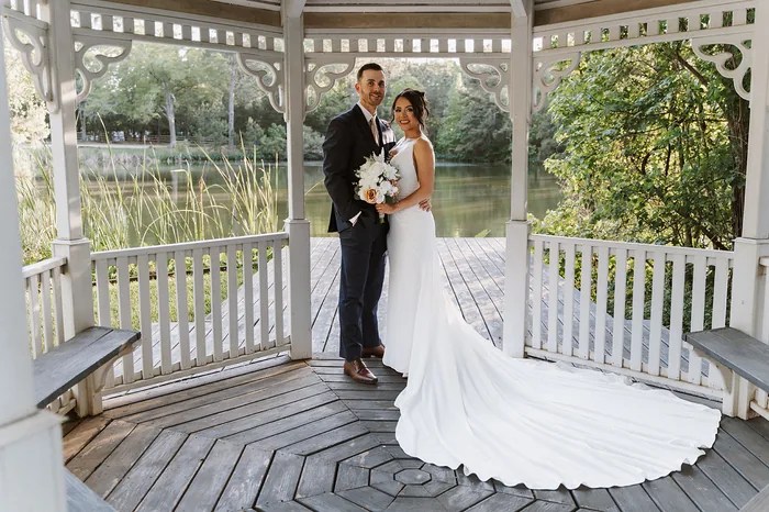 Bride and groom standing in the white gazebo overlooking the pond at Forever 5 Events, Conroe, TX