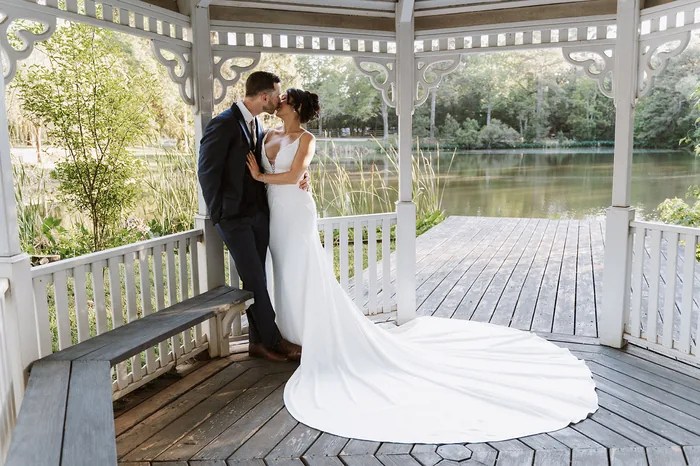Bride and groom kissing in the white gazebo at Forever 5 Events, Conroe, TX