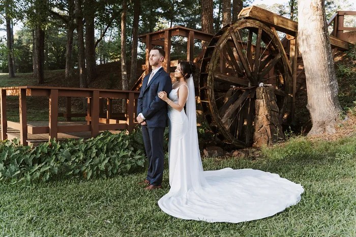 Bride and groom beside the rustic wooden water wheel at Forever 5 Events, Conroe, TX