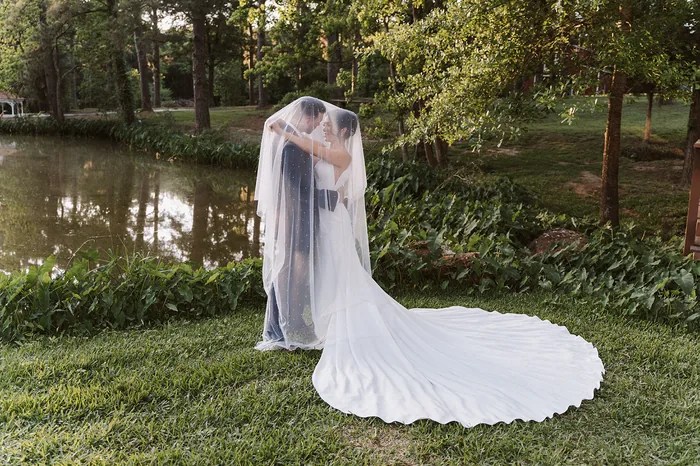 Bride and groom under a sheer veil at sunset by the pond at Forever 5 Events, Conroe, TX