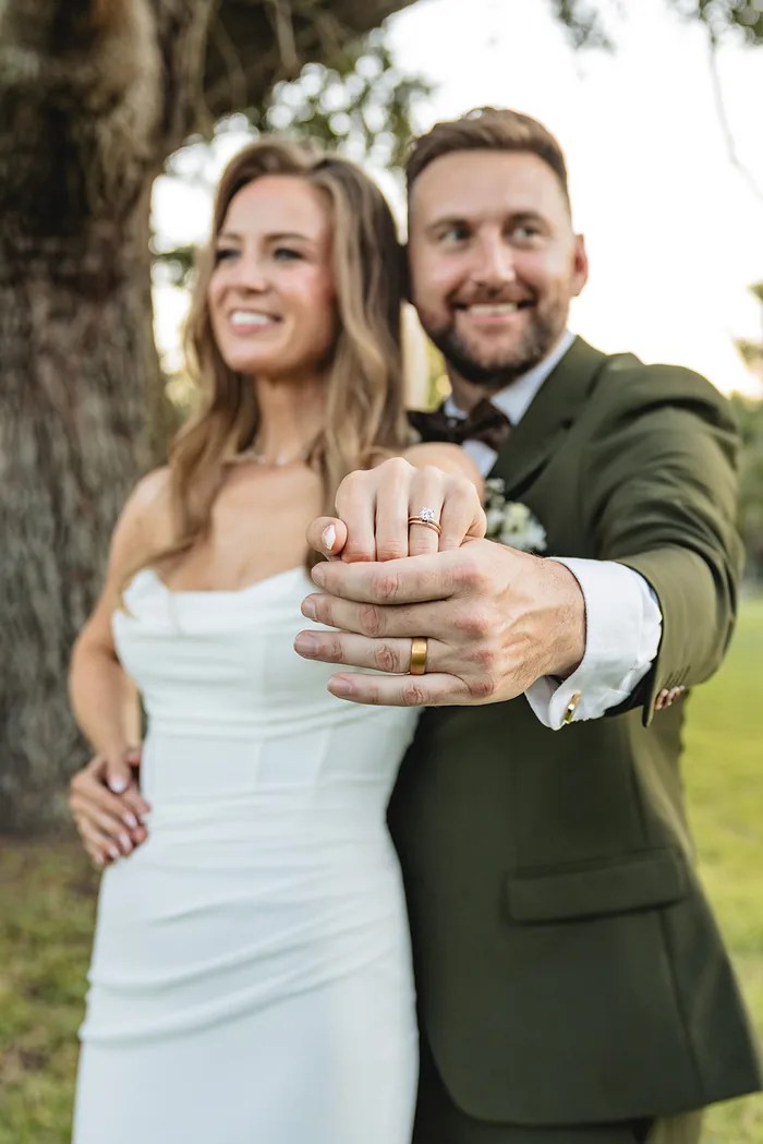 Close-up of the couple holding hands showing wedding rings at The Oaks at Oak Plantation, Texas