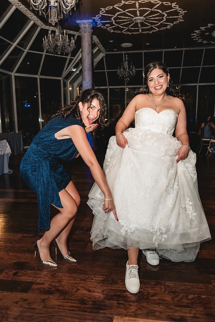 Bride getting dress adjusted by bridesmaid at Old San Francisco Steak House, Houston, TX