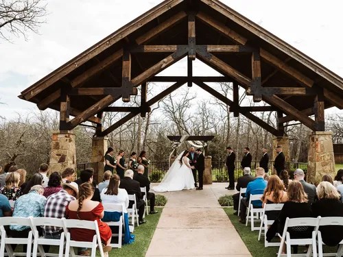 Wedding ceremony aisle under the wooden pavilion at The Springs Venue in Denton, Aubrey, TX
