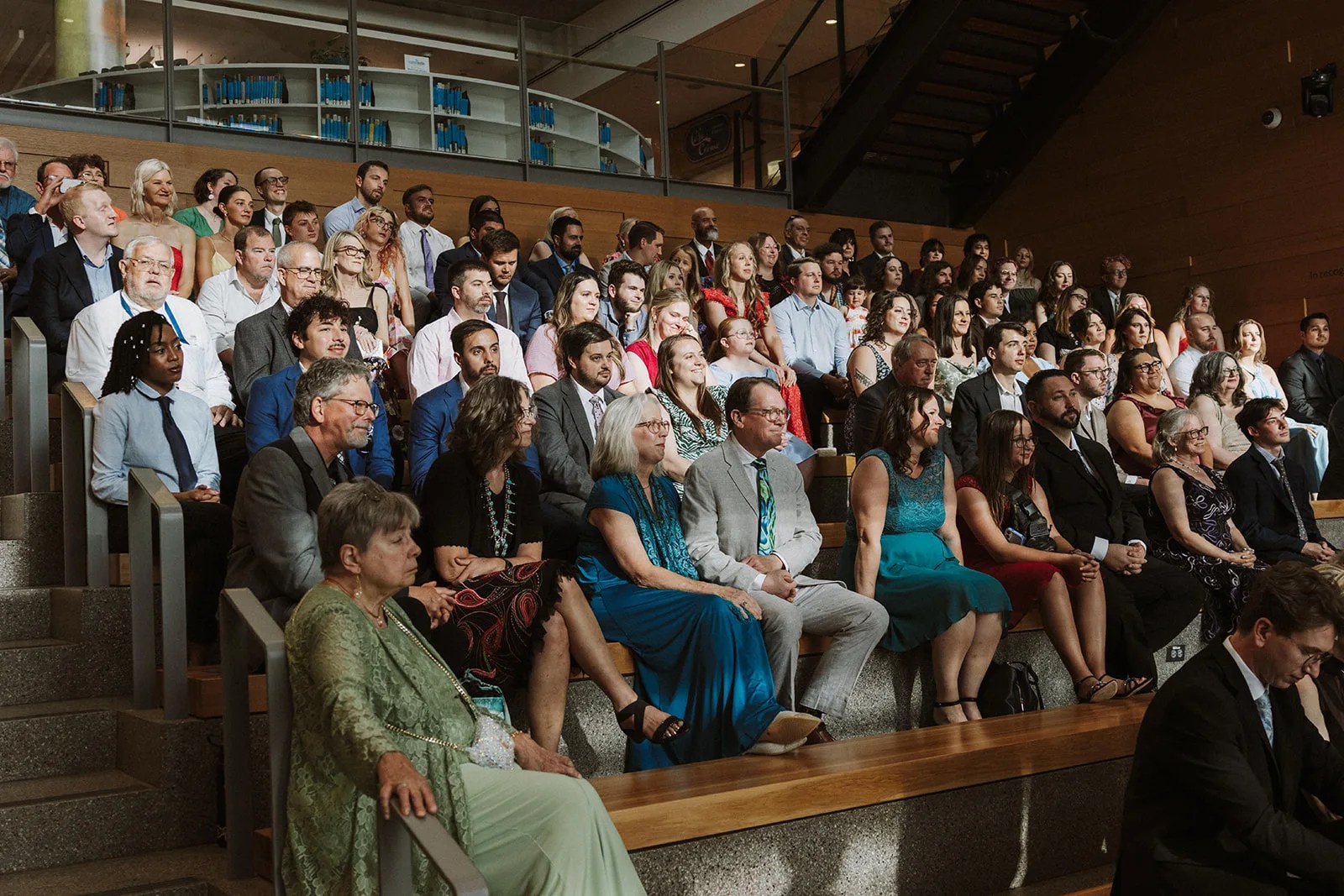 Austin Central Library wedding ceremony in Austin, TX, guests seated beneath floor to ceiling windows