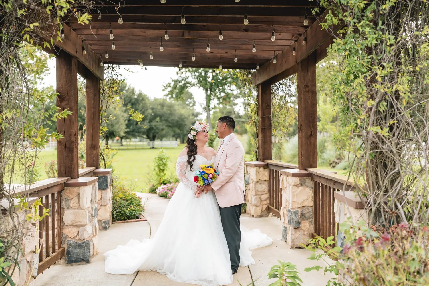 Bride beneath the stone arbor at Bonanza Ranch, Crosby, TX