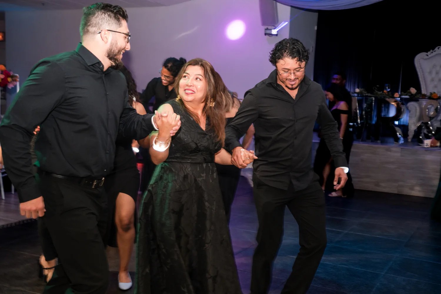 Guests on the dance floor under purple uplighting at Eden Events, Houston, TX