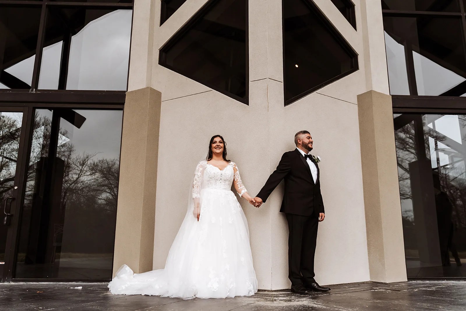 Bride and groom between the black steel beams at Jennings Trace in Montgomery, TX