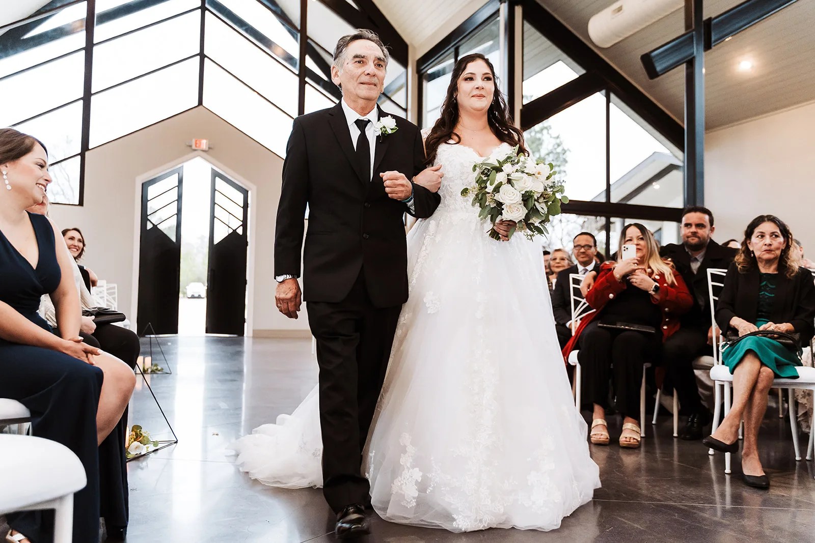 Bride walking the aisle in the glass chapel at Jennings Trace, Montgomery, TX