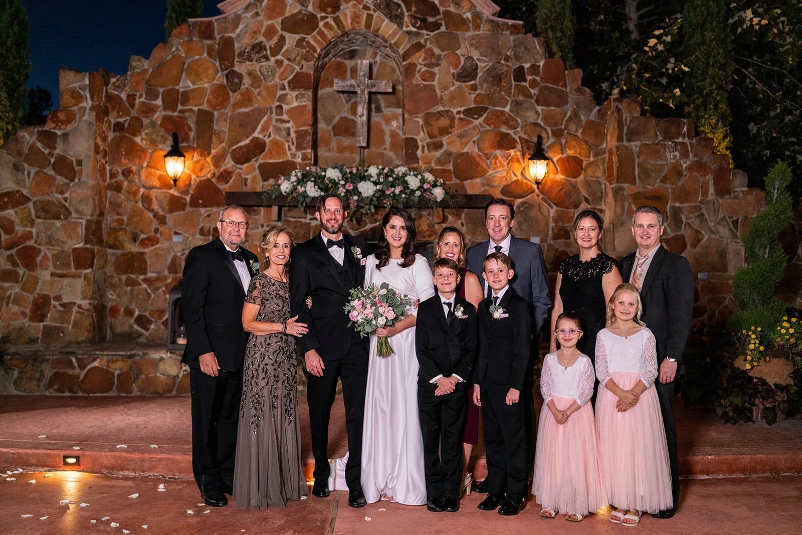 Wedding party against the stone wall at Madera Estates in Conroe, TX