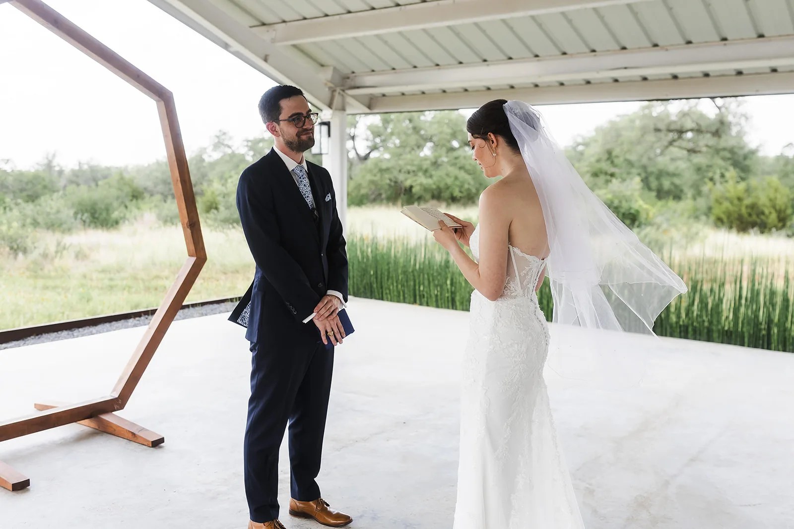 Couple under the ceremony arch on the pavilion at Mae's Ridge at Mae's Ridge, Johnson City, TX