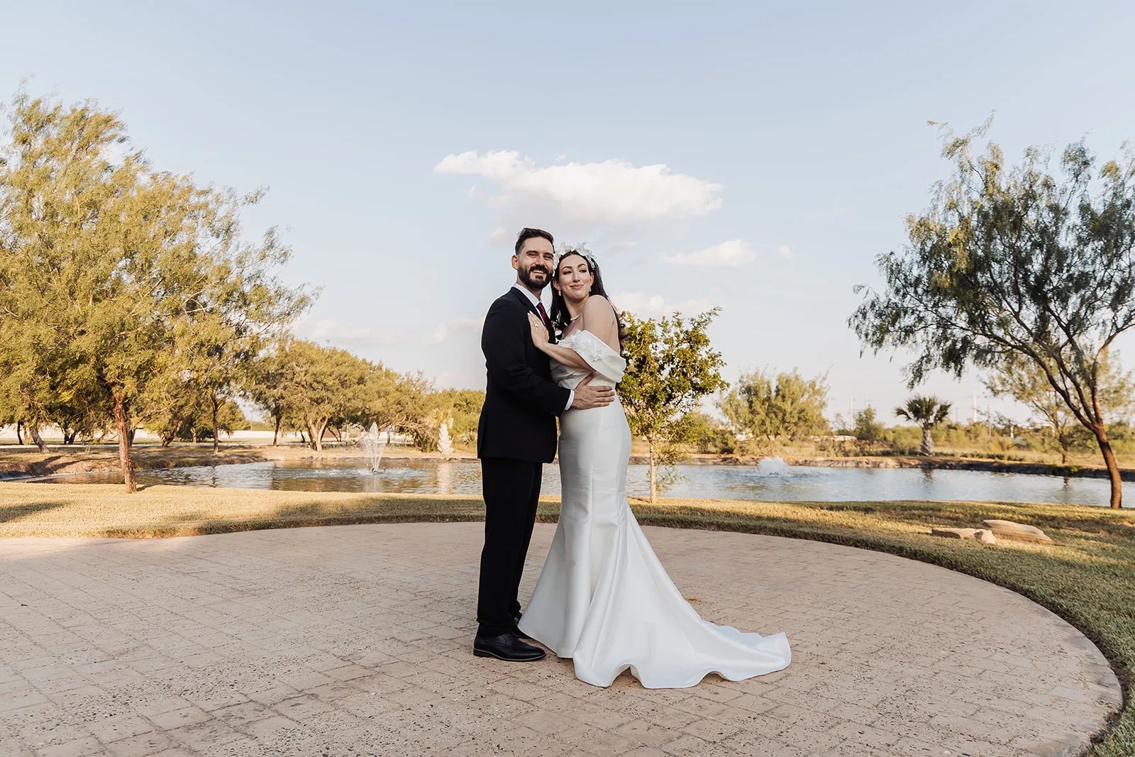 Bride and groom beside the fountain lake at Monarca Event Center in Edinburg, Texas
