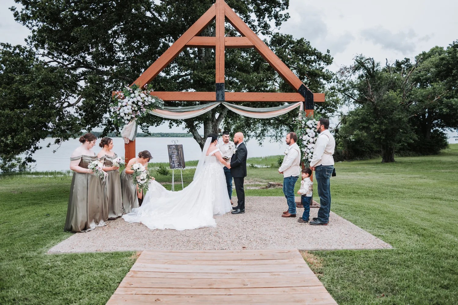 Bride and groom at the timber arch at Peninsula Ranch