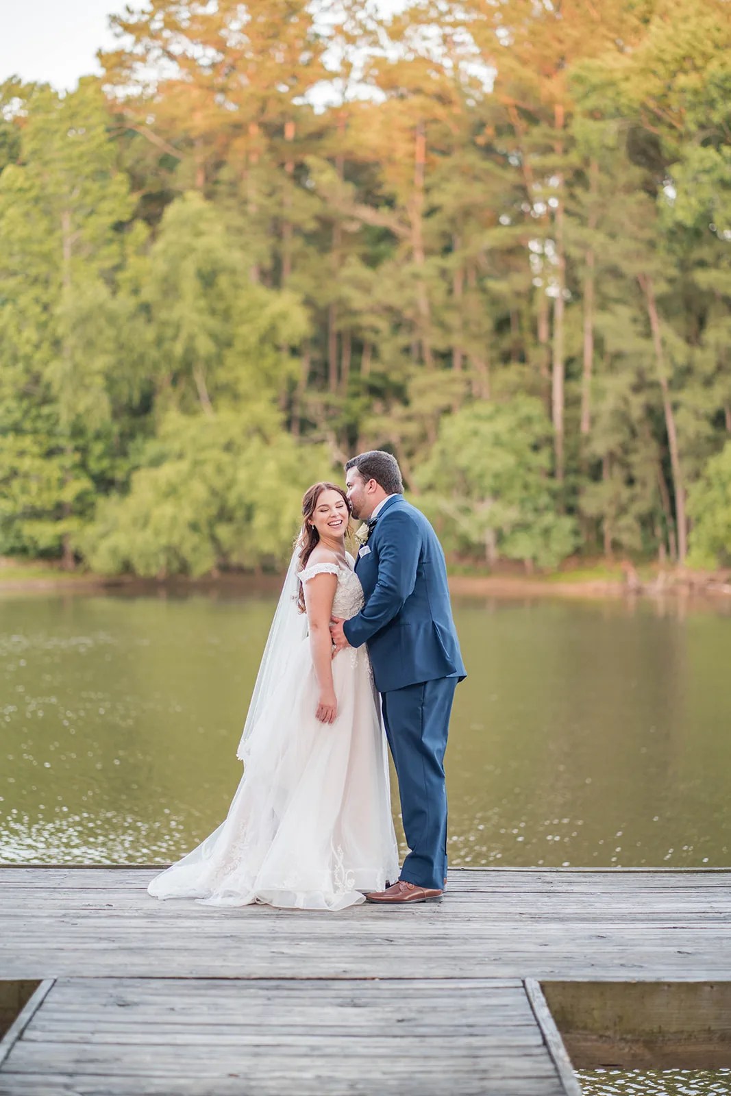 Bride and groom by the lake at Pine Lake Ranch in Montgomery, TX