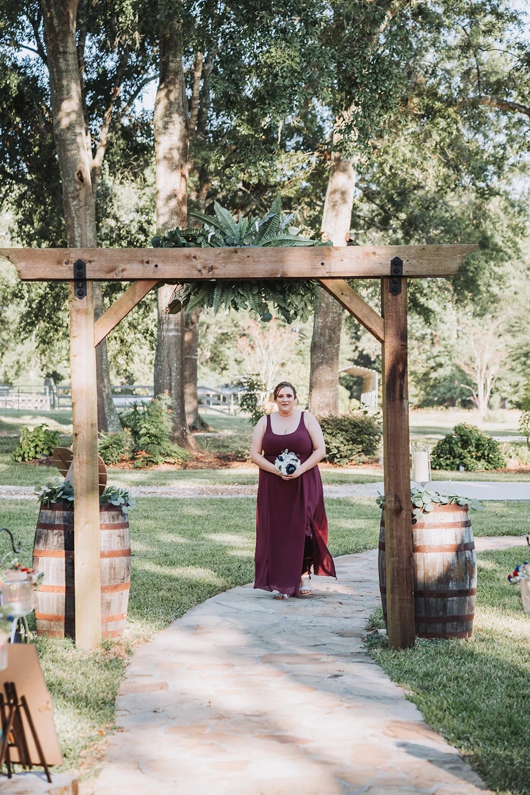 The arbor ceremony site with whiskey barrels at SJP Ranch, Cleveland, TX
