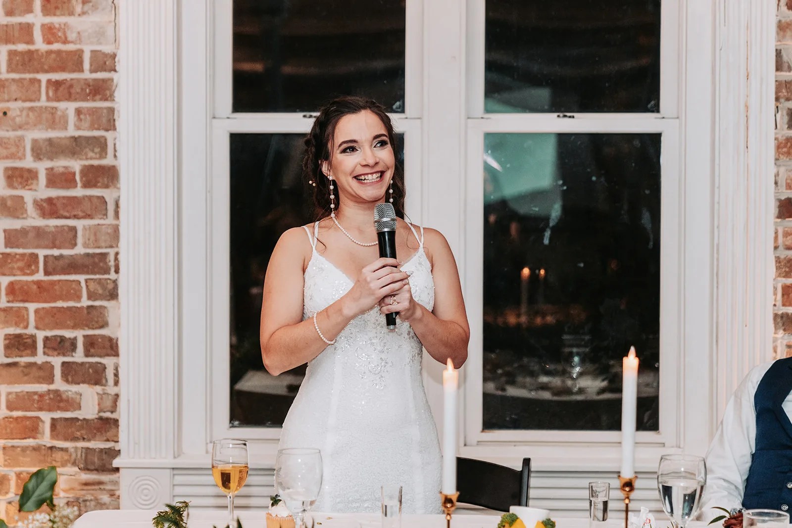 Bride against the exposed brick wall at Station 3 wedding venue in Houston, TX