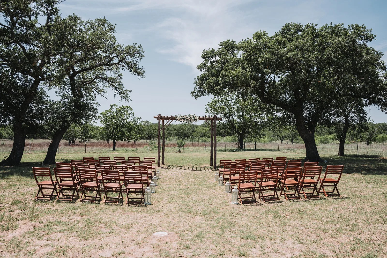 Ceremony chairs set beneath the arbor at The Ginger Ranch, Fredericksburg, TX