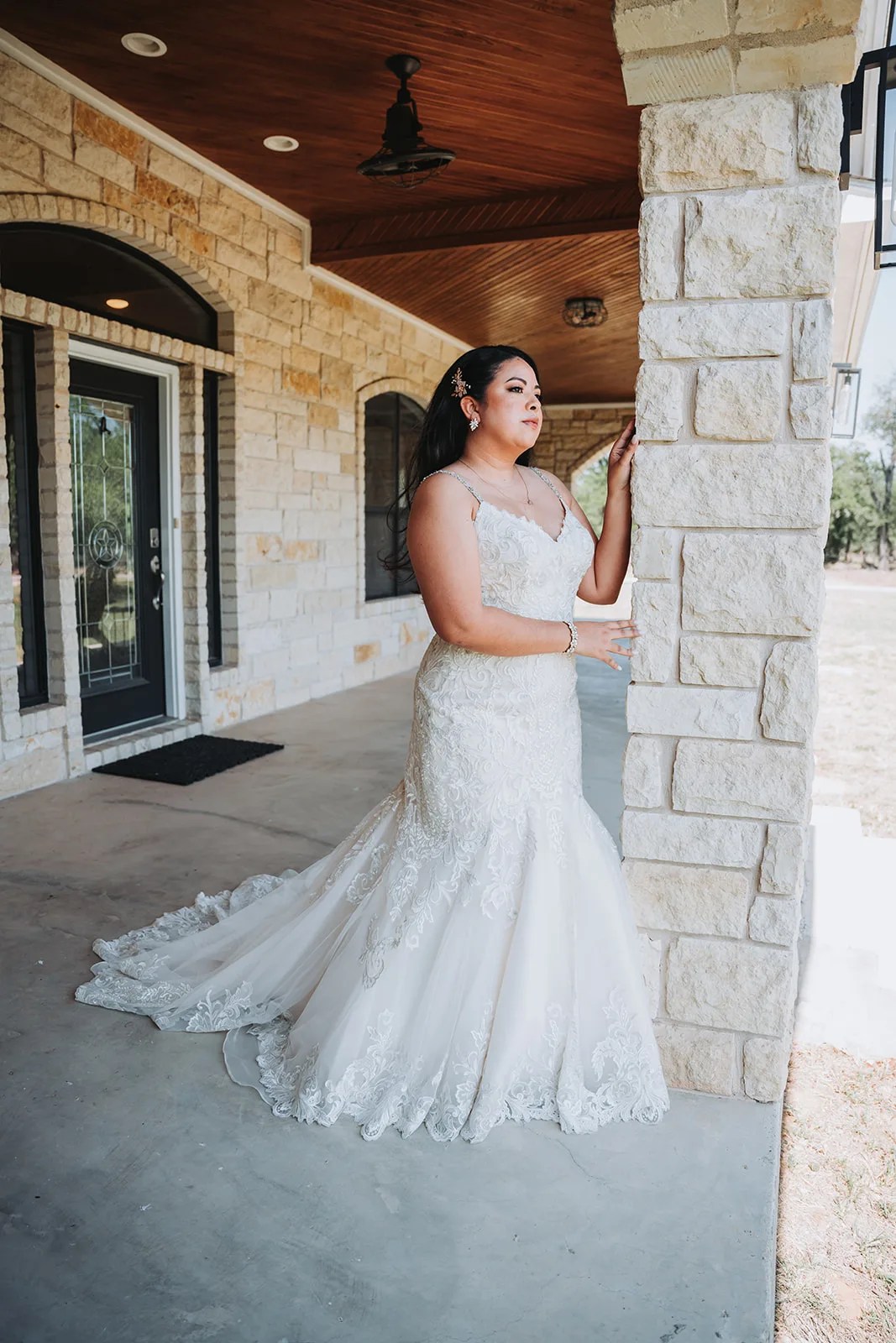 Bride against the limestone wall at The Ginger Ranch, Fredericksburg, TX