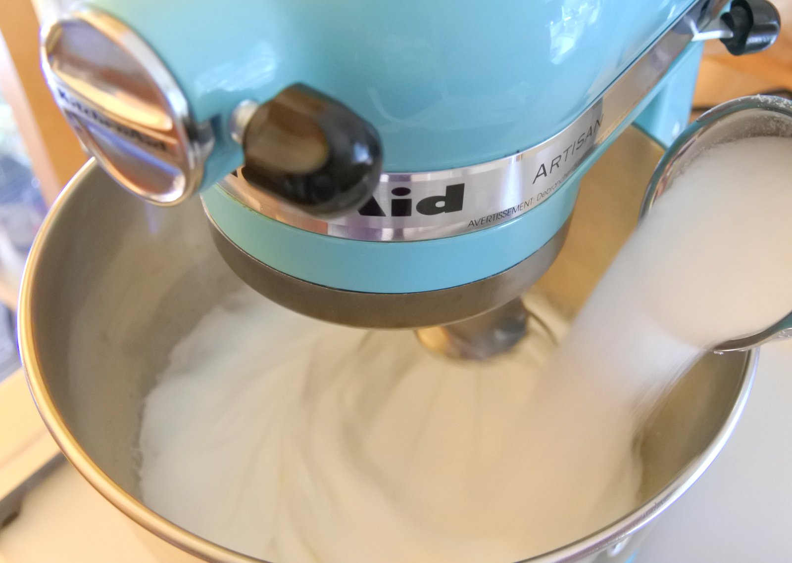 Add sugar to beaten egg whites