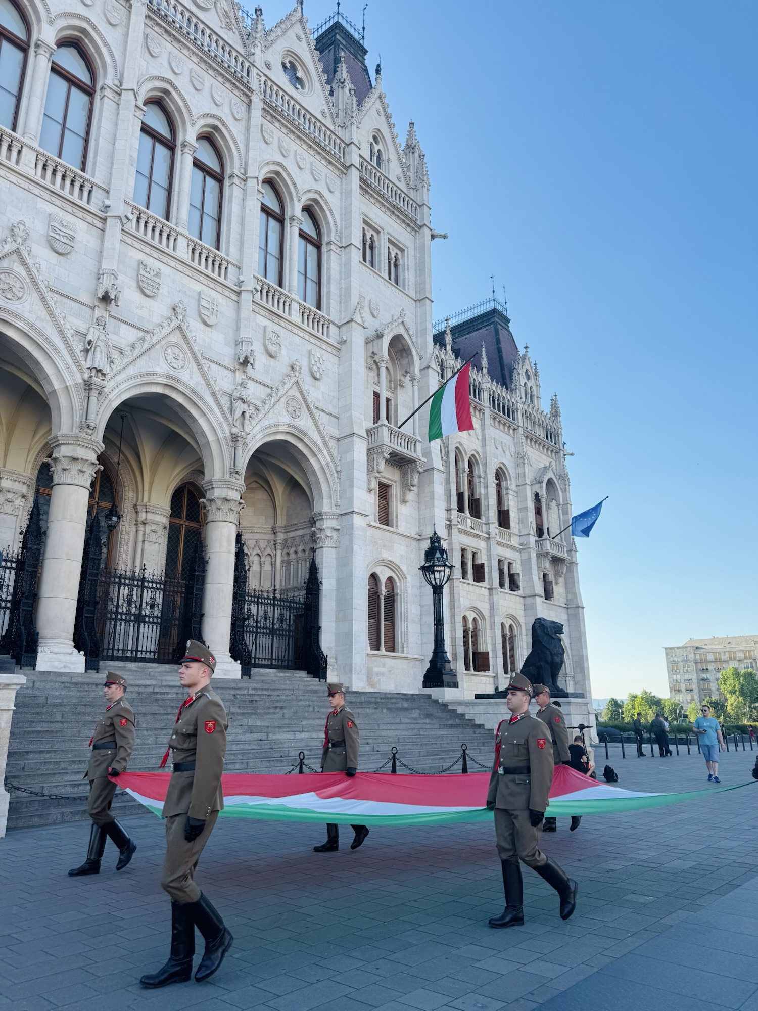 Hungarian Soldiers carrying national flag in front of Budapest Parliament Building