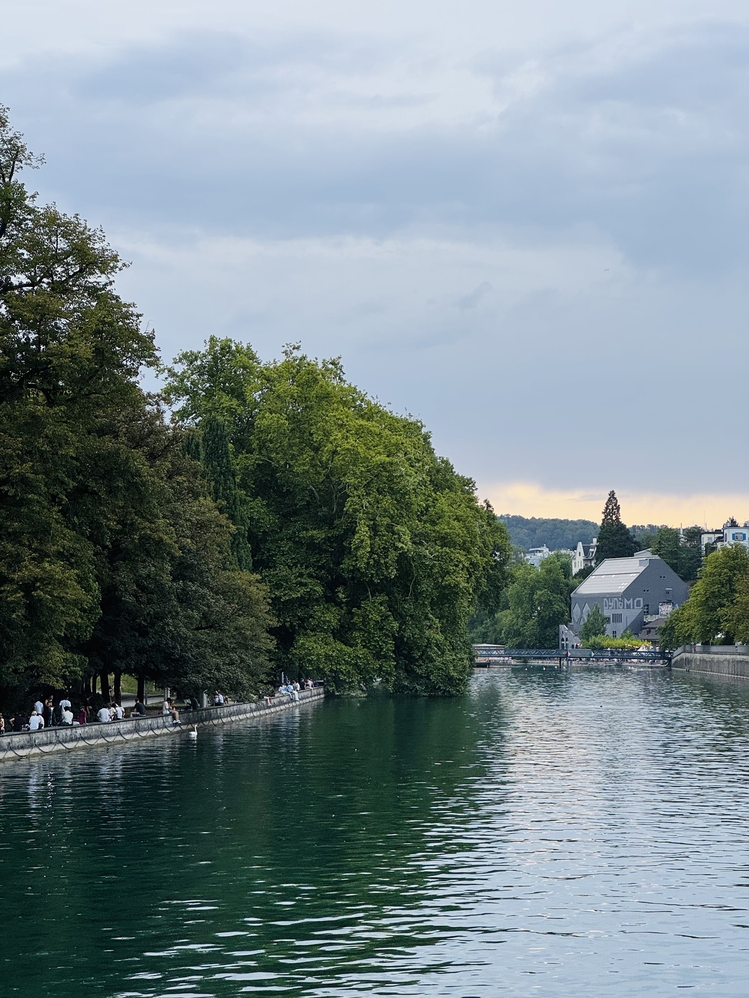 River in Zurich Switzerland in the evening with people socializing on shore