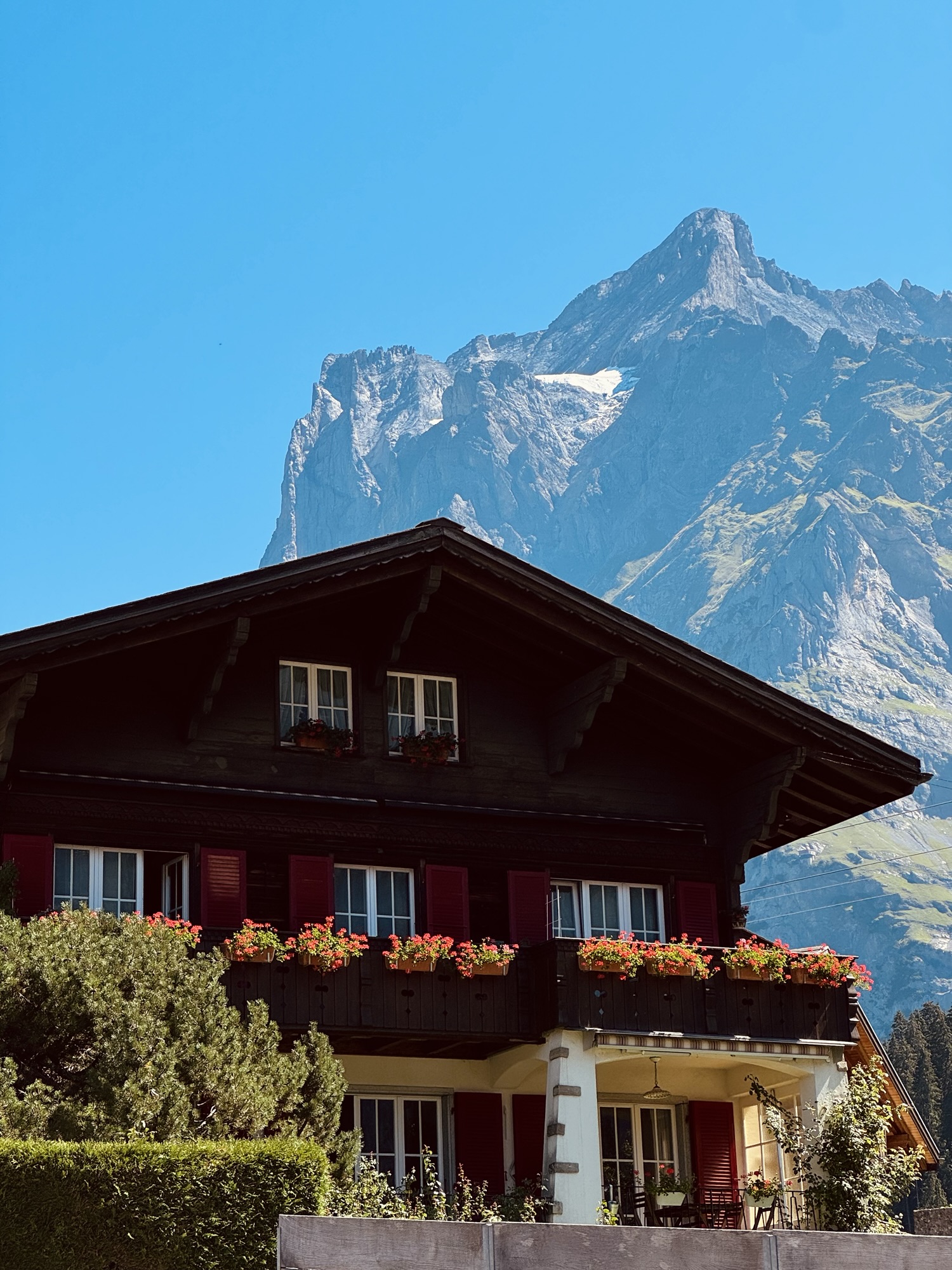Swiss home in Grindelwald Switzerland with florals on the balcony and mountain in the background