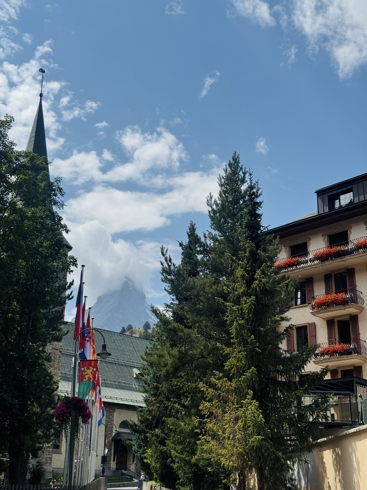 The view of Matterhorn mountain from a distance with trees and buildings in the foreground
