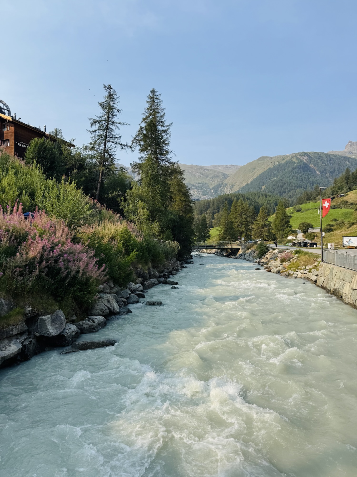 River running through Zermatt in Switzerland with greenery and florals on shore