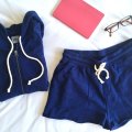 Pact Essential Hoodie and Drawstring short, flat lay style with glasses and a pink journal