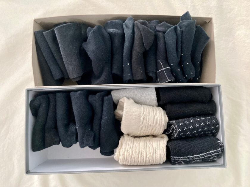 Two shoe boxes with socks folded neatly in them, as seen from above