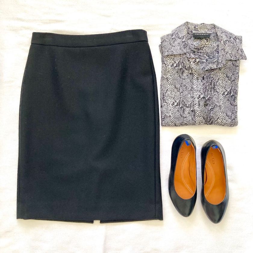 Flatlay of an outfit: a black pencil skirt, a snakeprint skirt, and black heels