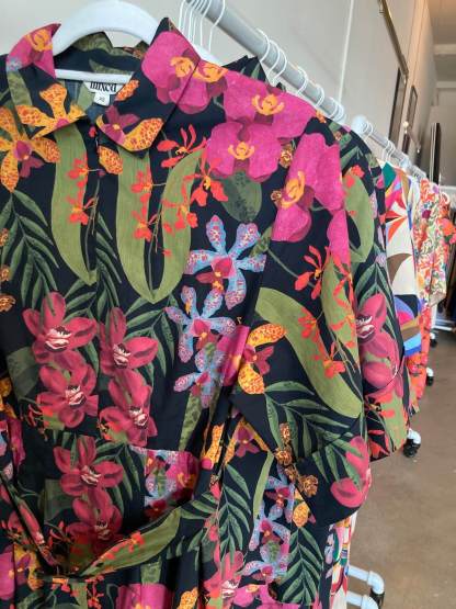 Closeup of the pink, green, black orchid print on a dress