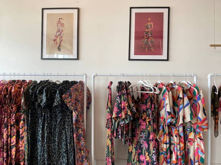 Colorful clothes hanging on white clothes racks.