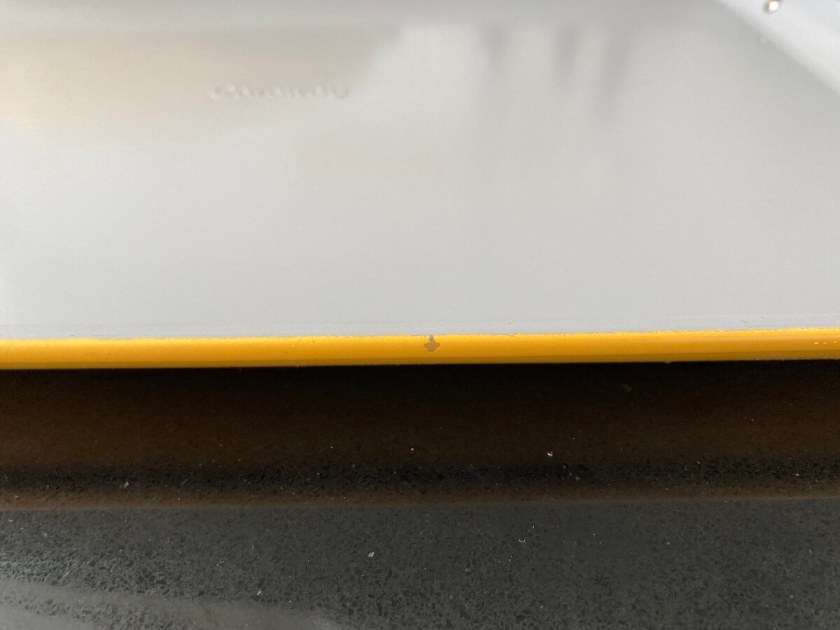 A chip on the side of a marigold Caraway bake sheet.