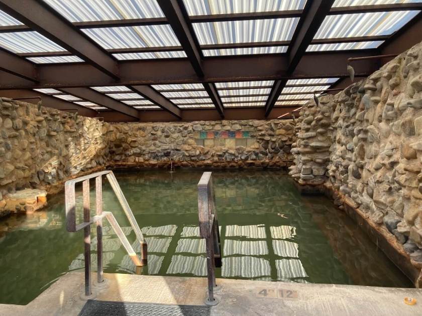 A covered pool, with rocks in the walls.
