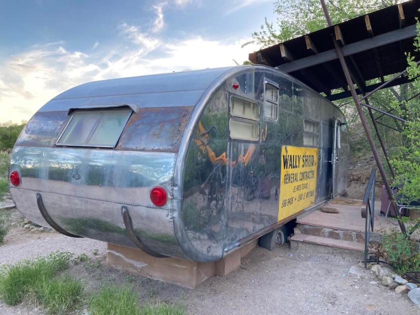 A vintage trailer with a patio built next to it.