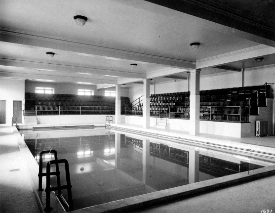 Indoor swimming pool with spectator seating area.