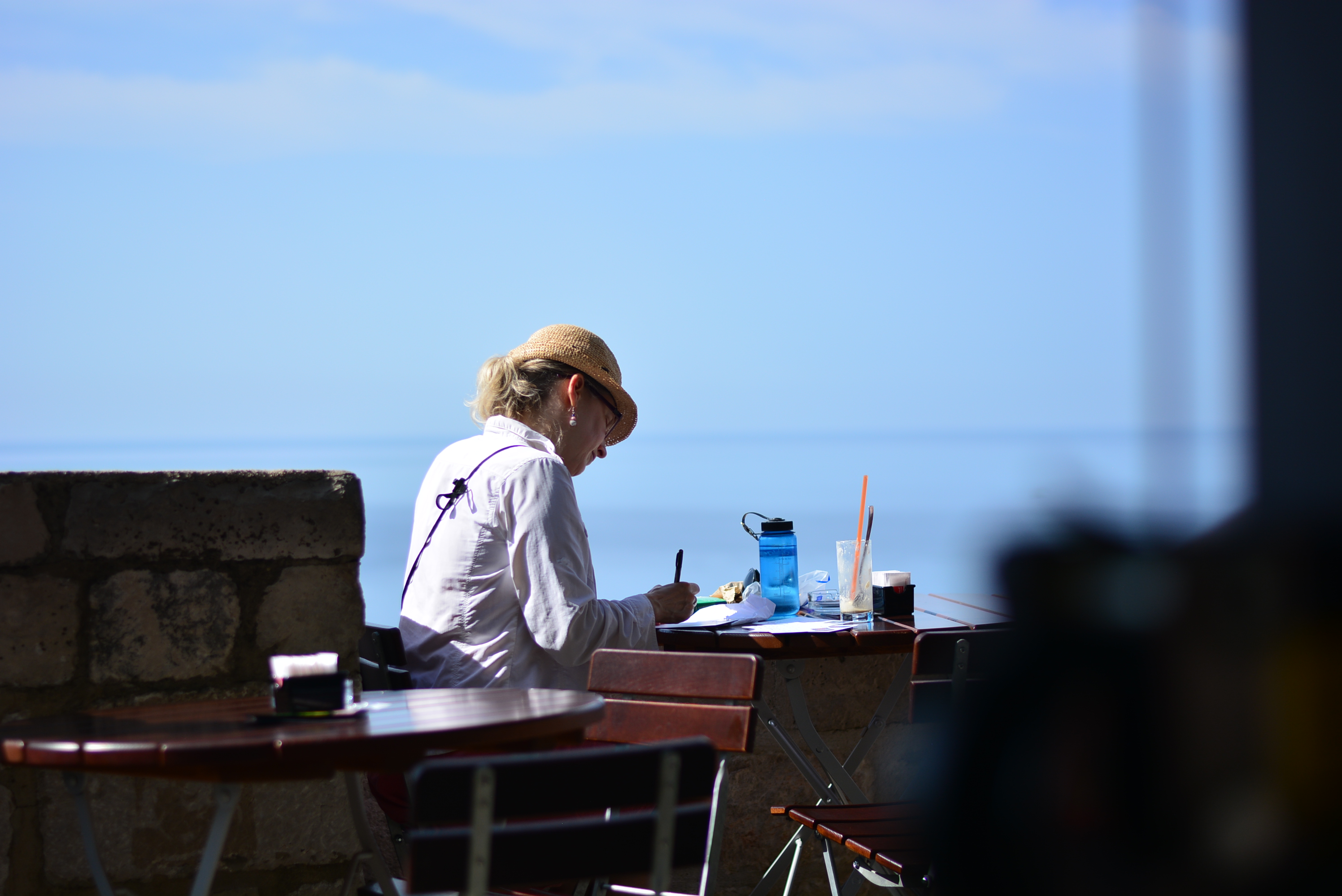 Fellow solo traveller writing postcards by the sea, on top of the city wall ^^ <3