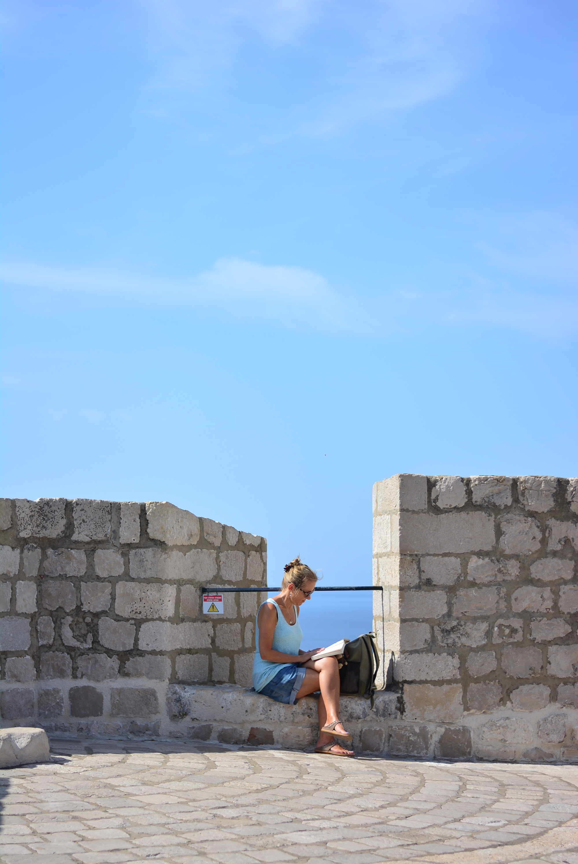 On the city wall (its a very very long city wall and this is one part of it only). Love to see fellow travellers enjoying alone time as well, so tranquil, by the sea reading. <3