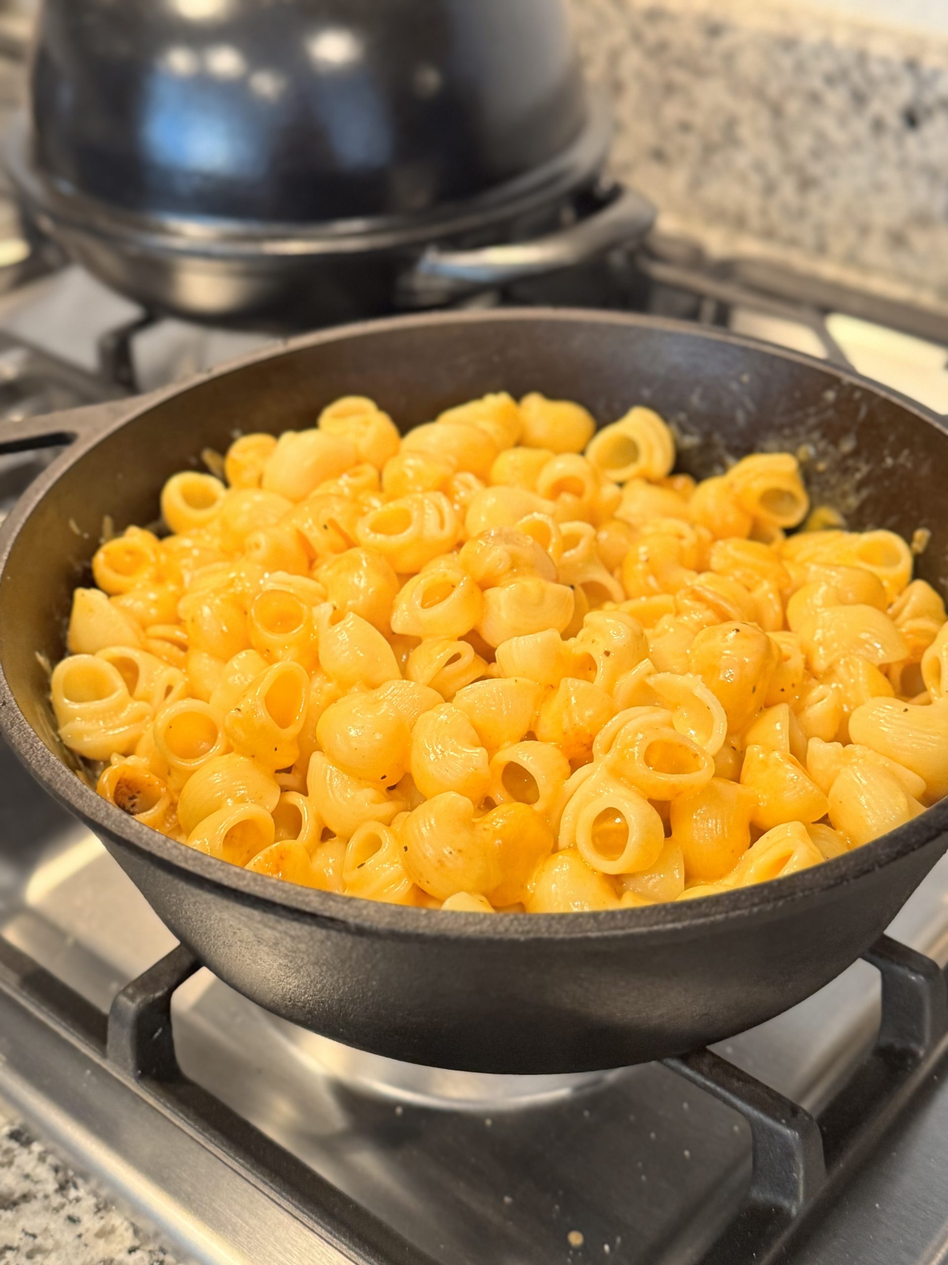 Smoked triple-cheese mac and cheese shells in a cast iron skillet