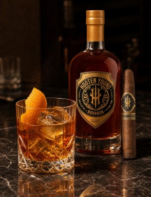Hooten Young bourbon bottle beside an Old Fashioned with orange peel