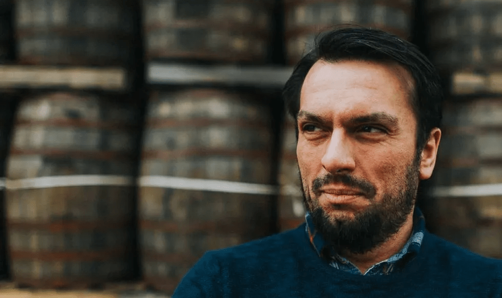 Bry Simpson in front of whisky barrels