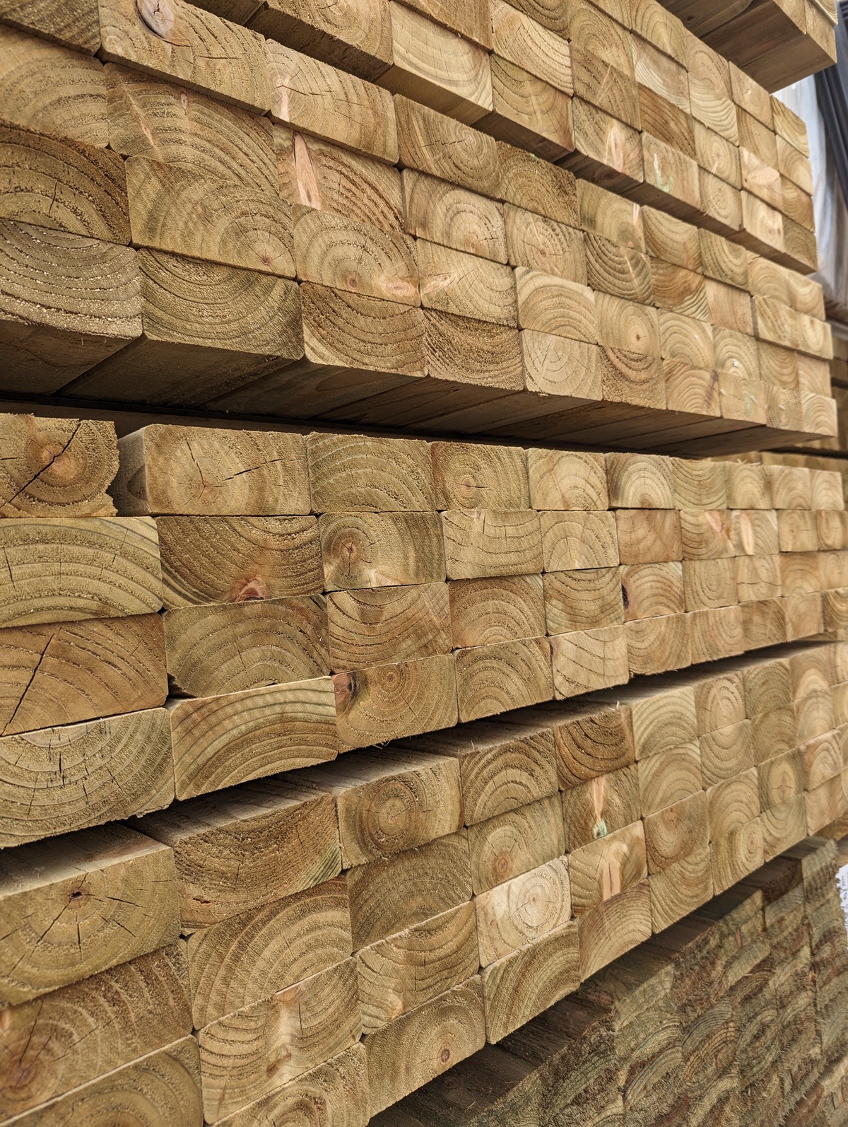 Stacked wooden beams showing end grain patterns.
