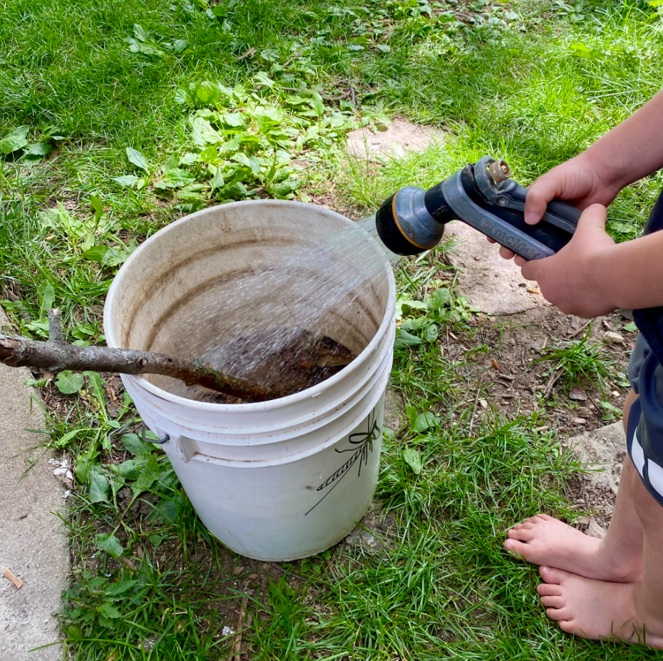 My son helping me build our mosquito bucket of doom.