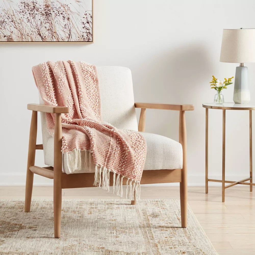 pink throw blanket on a mid-century modern style chair