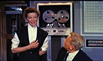 Katherine Hepburn and Spencer Tracy with a large computer in the background.