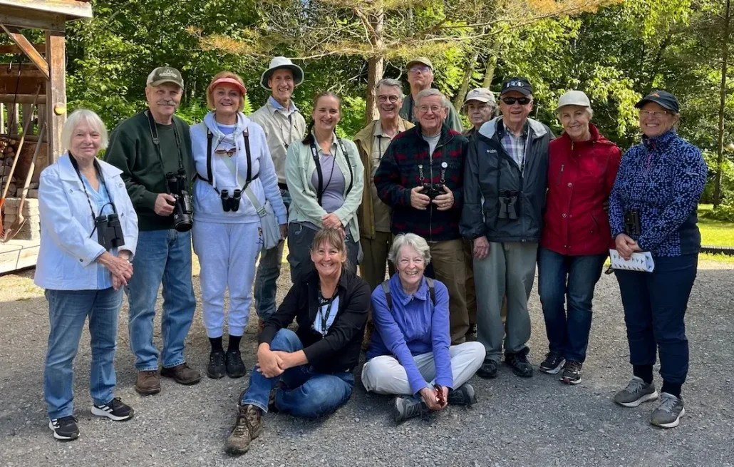 A group of club members with binoculars posing during a Fall Migration outing