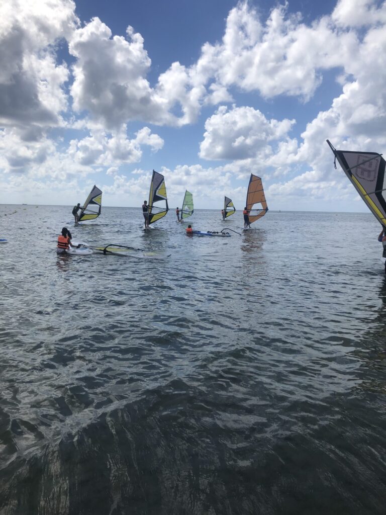 Grupo tomando clases de windsurf en el mar en santa pola