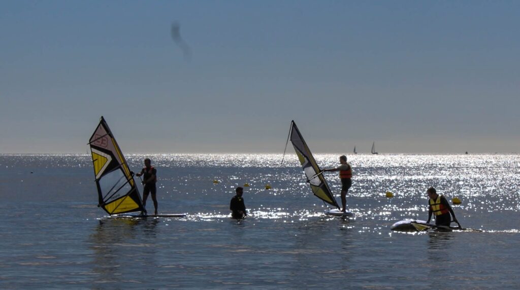 Monitor enseñando windsurf a tres personas