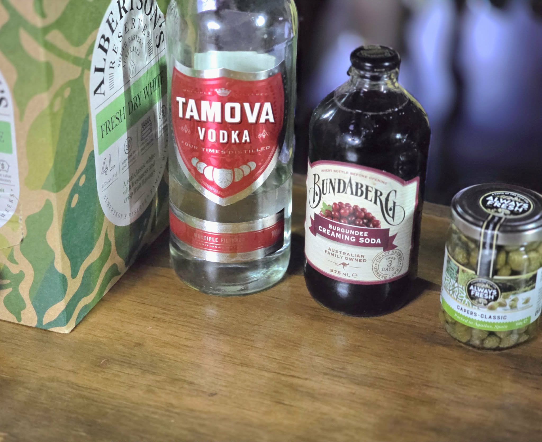 Wine cocktail with white wine, vodka, creaming soda and capers.